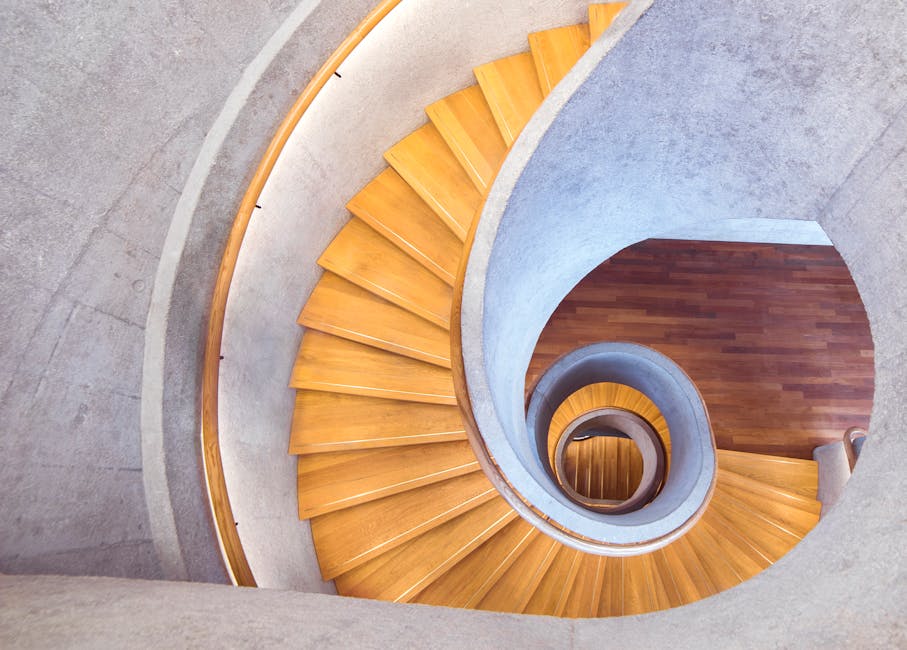 Aerial view of a stylish spiral staircase with wooden steps and a concrete interior