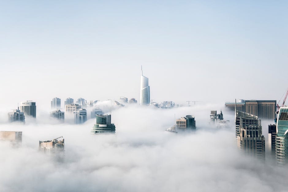 A stunning view of Dubai skyscrapers emerging through a blanket of fog, showcasing modern architecture