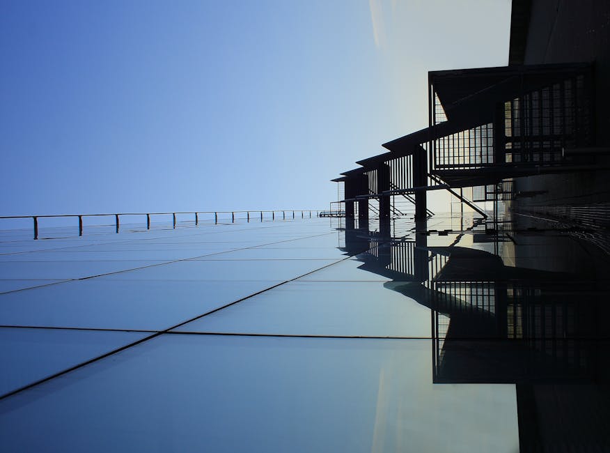 A striking glass skyscraper reflecting blue skies, showcasing modern architecture's elegance